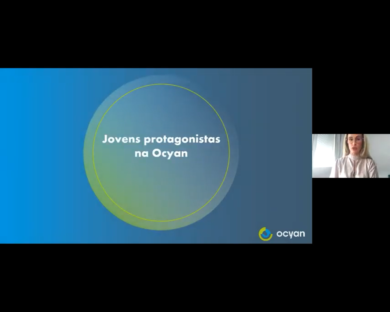 Uma mulher apresenta um slide com o texto 'Jovens protagonistas na Ocyan'